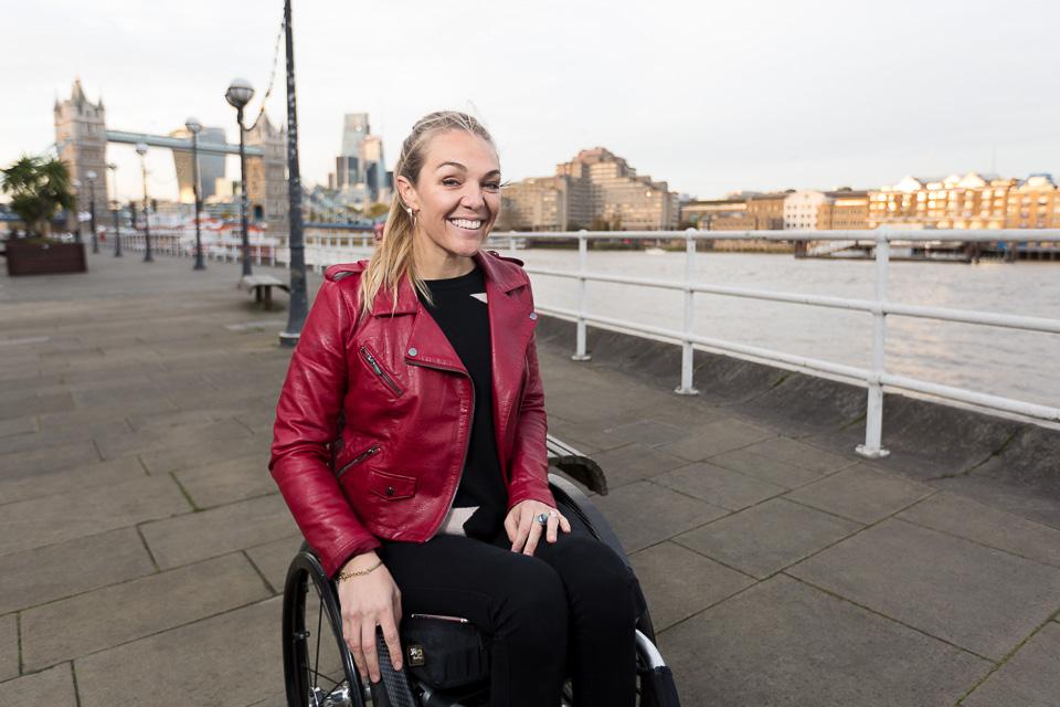 Sophie Morgan smiles on London's South Bank with the Thames and London Bridge in the background.